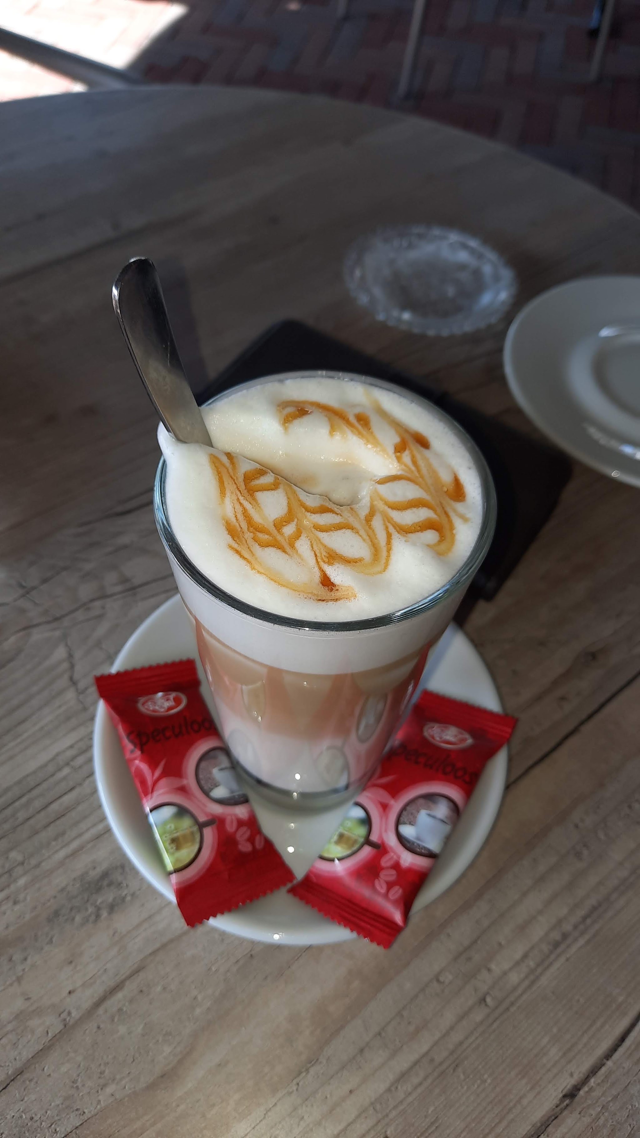 Latte met versierd melkschuim op een houten tafel