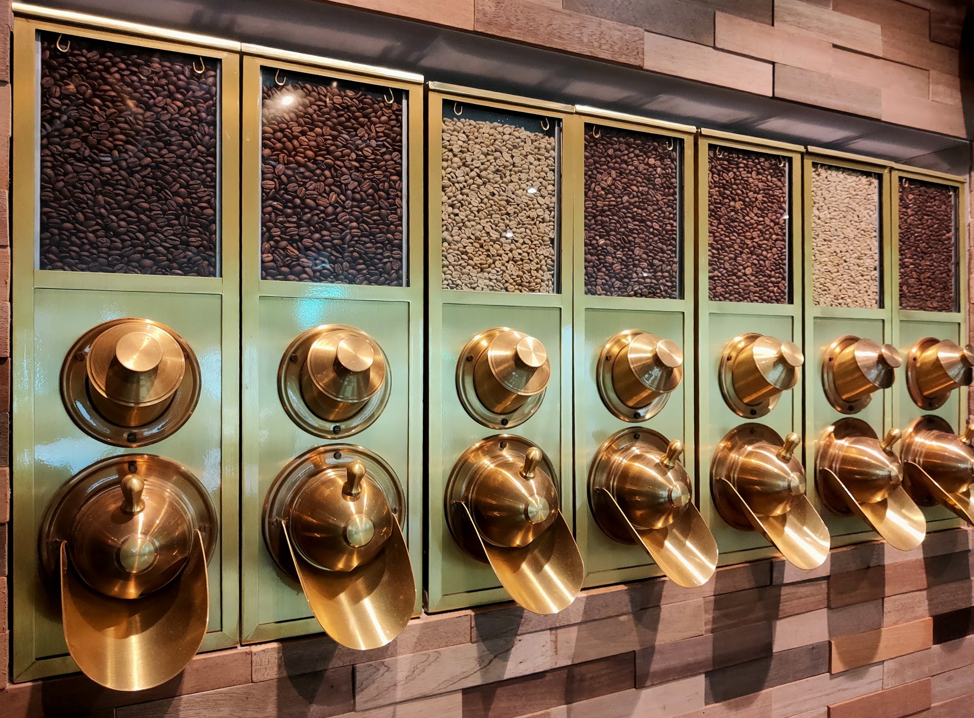 Koffiebonen in de goudkleurige dispensers in de zaak
